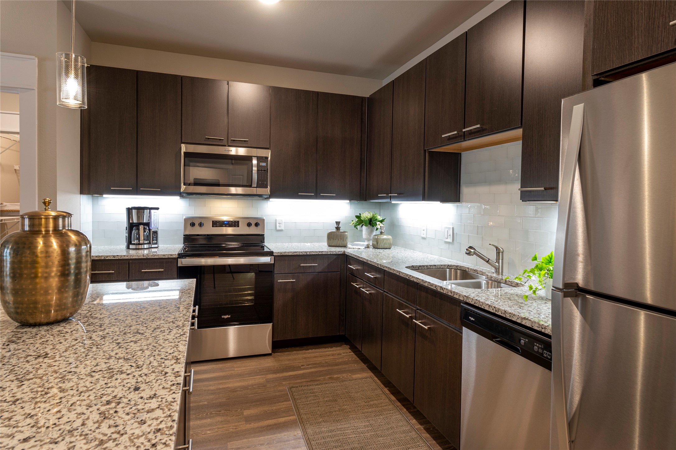 1616 Partnership Way, Unit 2219 Katy, TX 77449 - Photo 20 of 22 a kitchen with stainless steel appliances granite countertop a refrigerator a stove a sink and a microwave