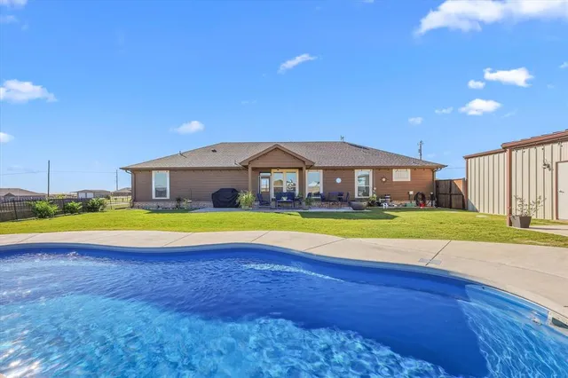 a swimming pool with outdoor seating and yard