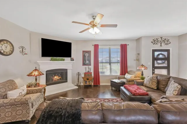 a living room with furniture a fireplace and a flat screen tv