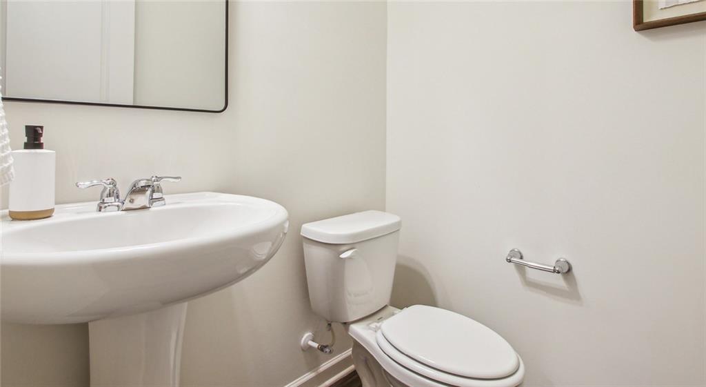 3373 Fence Road Northeast, Unit D4 Dacula, GA 30019 - Photo 38 of 40 a bathroom with a sink a mirror and a toilet