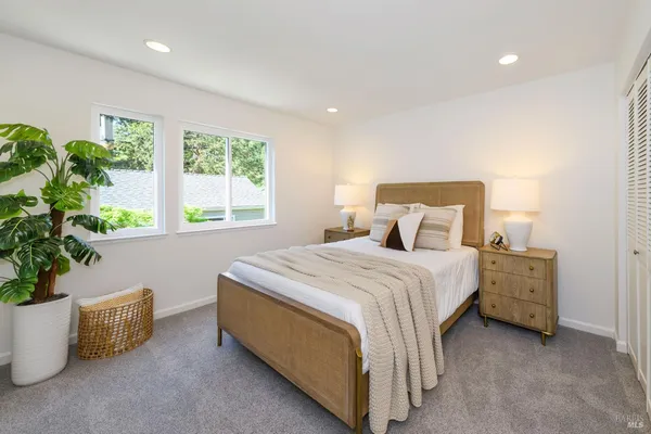 a bed sitting in a spacious bedroom next to a window