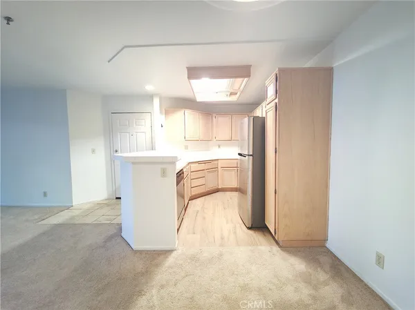 a view of a kitchen with a sink and a refrigerator