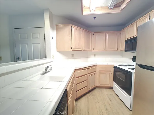 a kitchen with granite countertop a sink stainless steel appliances and white cabinets
