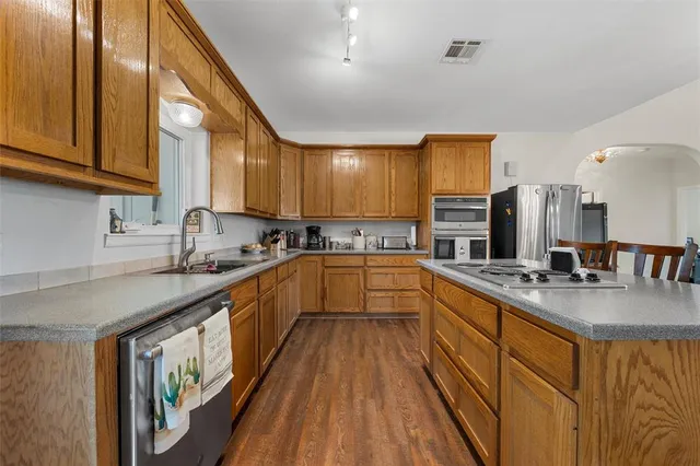 a kitchen with stainless steel appliances granite countertop sink stove microwave and cabinets