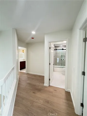 a view of a hallway with wooden floor and a living room