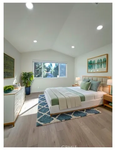 a spacious bedroom with a large bed and a wooden floor