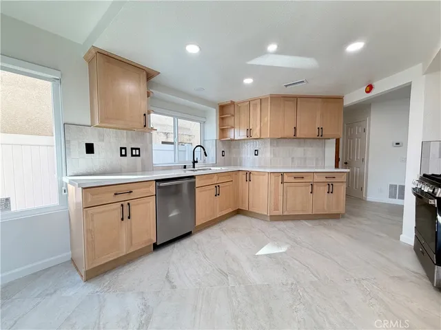 a kitchen with white cabinets appliances and a window