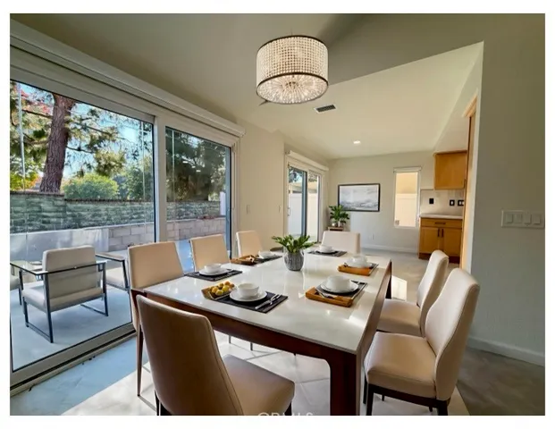 a dining room with furniture a chandelier and wooden floor