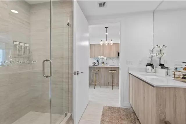 a bathroom with a sink shower and a mirror