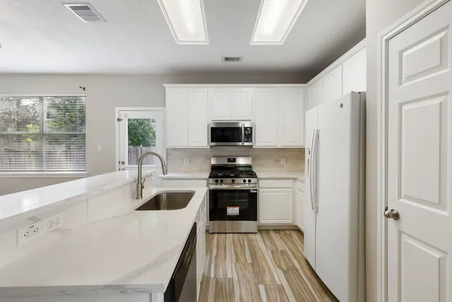 a kitchen with a stove a refrigerator and a sink