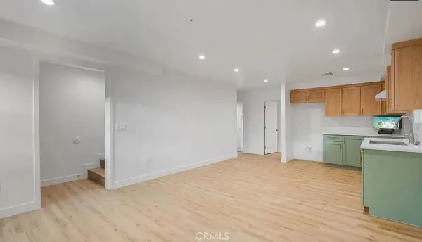 a kitchen with a sink cabinets and wooden floor