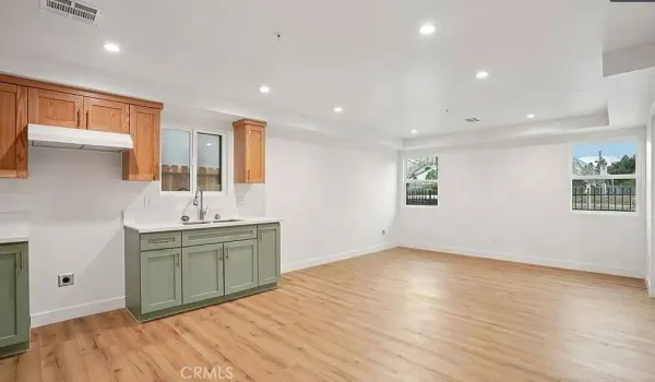 a kitchen with a sink cabinets and wooden floor