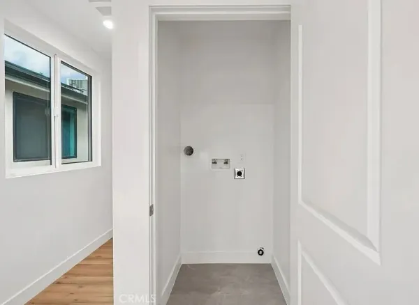 a view of an empty room with wooden floor and closet