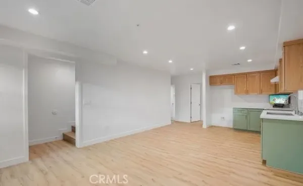 a kitchen with a sink cabinets and wooden floor