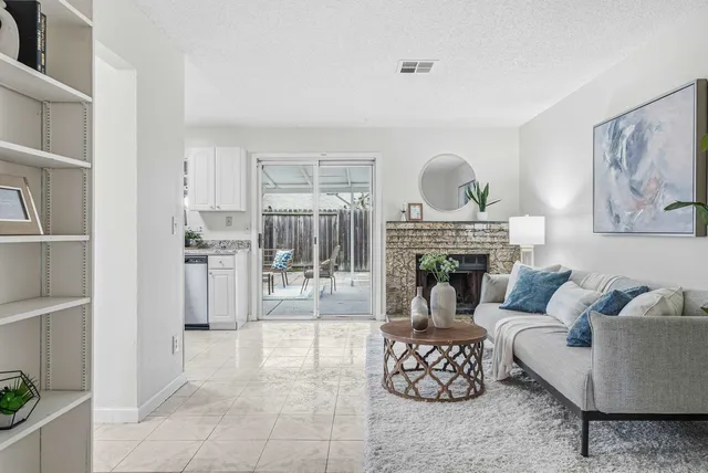 a living room with furniture a fireplace and a table