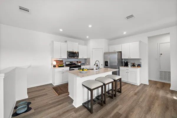 a kitchen with white cabinets and stainless steel appliances