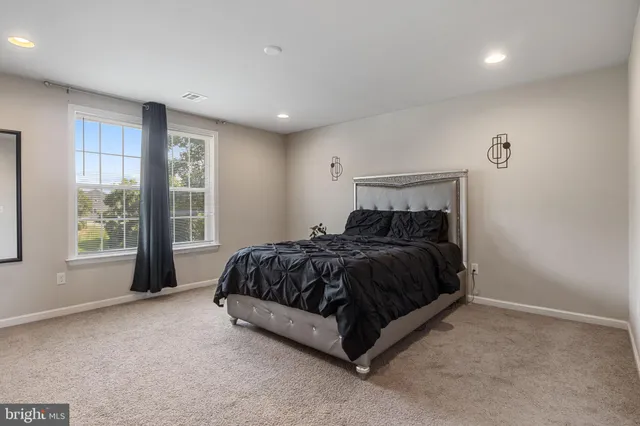 a spacious bedroom with a bed and a table in it