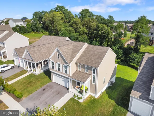 an aerial view of residential houses with outdoor space and parking