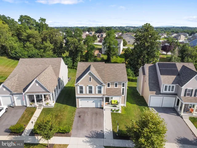an aerial view of residential houses with outdoor space and parking