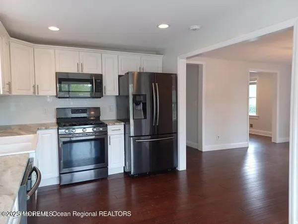 a kitchen with stainless steel appliances granite countertop a refrigerator microwave and stove top oven