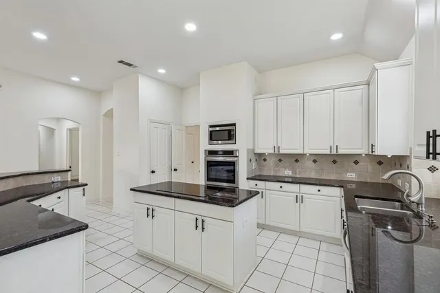 a kitchen with stainless steel appliances granite countertop a sink and cabinets