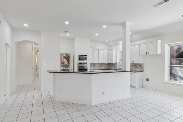 a kitchen with stainless steel appliances granite countertop a refrigerator and a sink