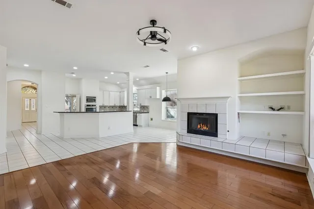 a view of a kitchen with a sink hardwood floor and a fireplace