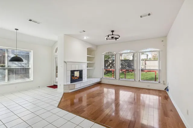 a view of an empty room with a fireplace and a window