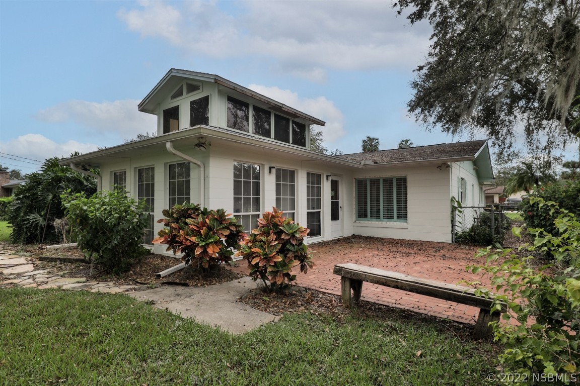 1701 Orange Tree Drive Edgewater, FL 32132 - Photo 1 of 21 a front view of a house with a garden and sitting area