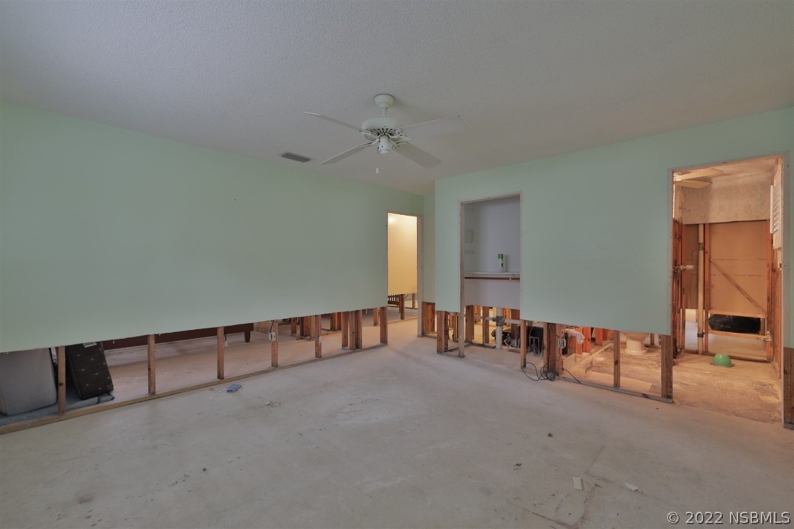 1701 Orange Tree Drive Edgewater, FL 32132 - Photo 12 of 21 an empty room with chandelier fan and windows