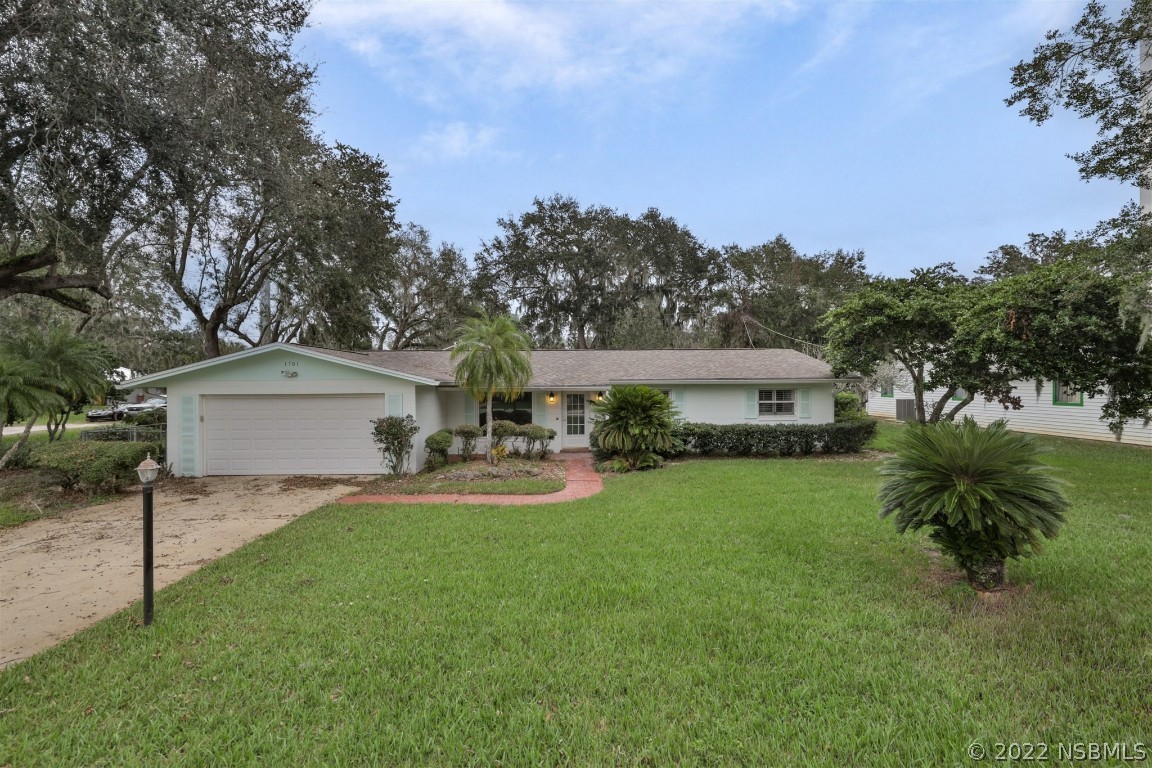 1701 Orange Tree Drive Edgewater, FL 32132 - Photo 3 of 21 a front view of a house with garden and trees