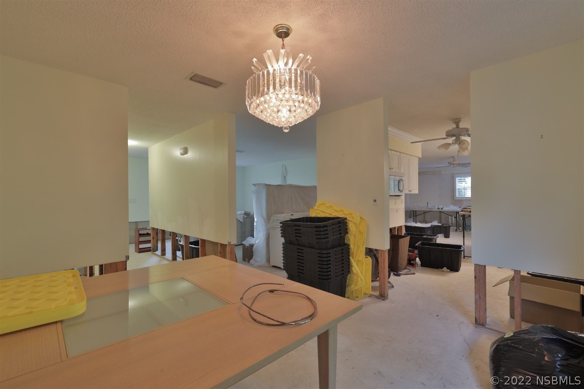 1701 Orange Tree Drive Edgewater, FL 32132 - Photo 10 of 21 a bed room with a bed mirror and a chandelier