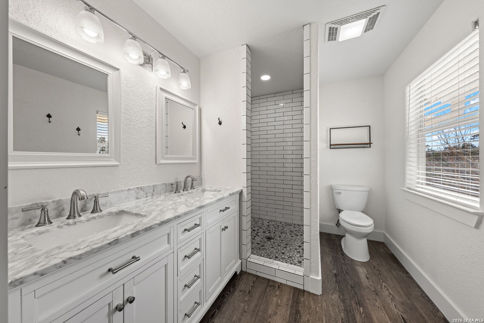 667 Ranch Rim Drive West Ingram, TX 78025 - Photo 5 of 50 a spacious bathroom with a granite countertop toilet sink double and mirror