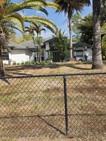 a view of a house with backyard and sitting area