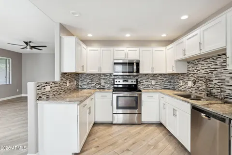 a kitchen with stainless steel appliances granite countertop a sink stove microwave and cabinets