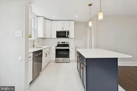 a kitchen with kitchen island a sink stainless steel appliances and cabinets