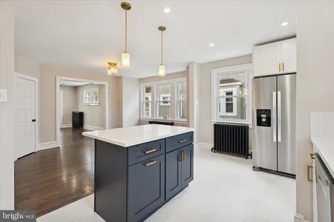 a kitchen that has a lot of cabinets and wooden floor