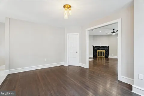 a view of empty room with wooden floor and fireplace
