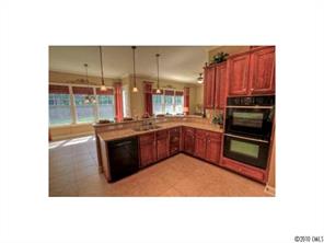 556 Quicksilver Trail Fort Mill, SC 29708 - Photo 3 of 15 a kitchen with kitchen island granite countertop a refrigerator and a sink