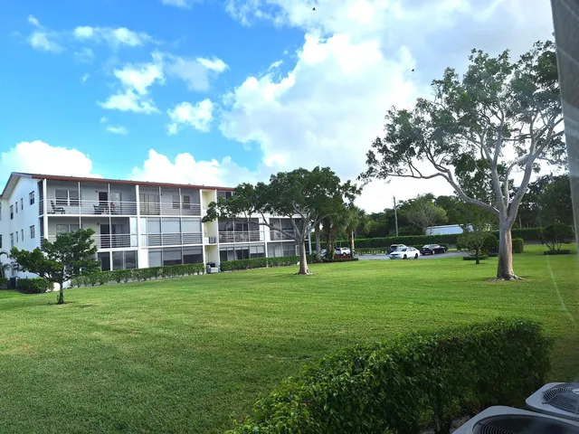 a view of a big yard with a house and large trees