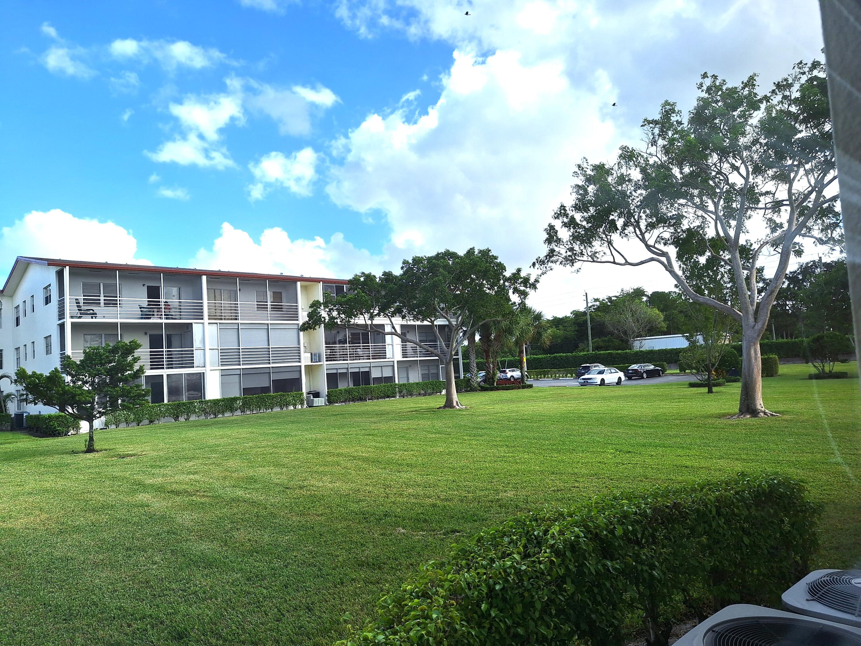 a view of a big yard with a house and large trees