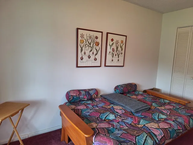 a bed room with a bed and a chair