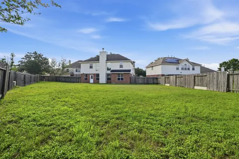 a view of a house with a big yard and large trees