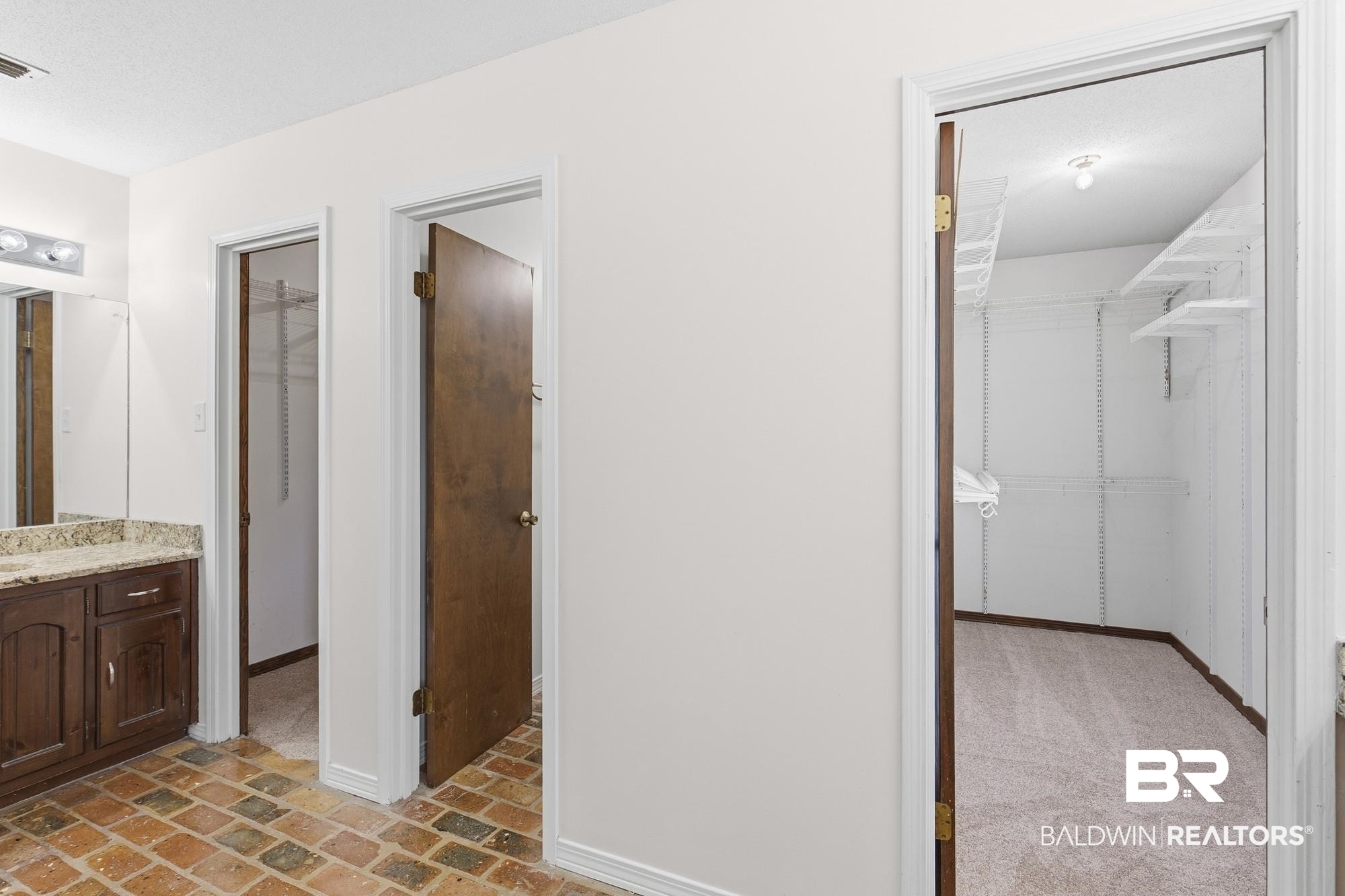 9215 Shiloh Drive Mobile, AL 36695 - Photo 19 of 32 Bathroom featuring a spacious closet, vanity, and brick flooring