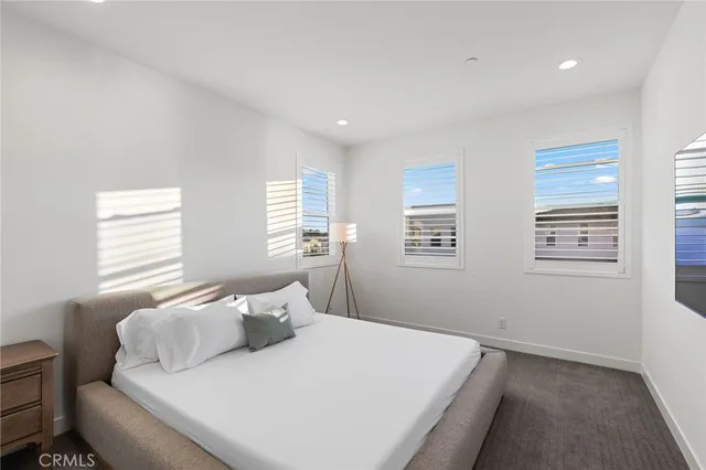 a bedroom with a bed tv and a window