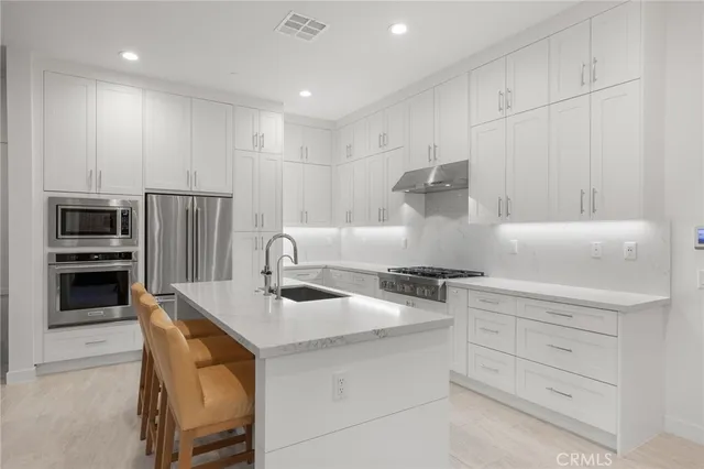 a kitchen with stainless steel appliances granite countertop a stove and a refrigerator