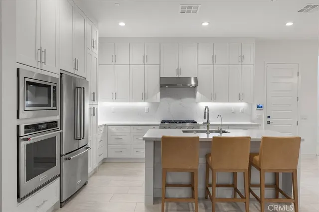 a kitchen with kitchen island granite countertop a stove oven and white cabinets