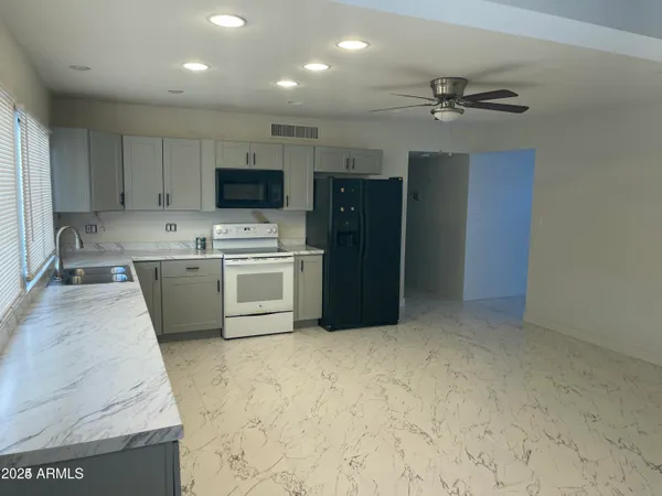 a kitchen with a refrigerator sink and cabinets