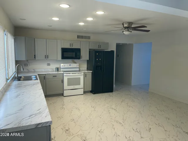 a kitchen with a refrigerator sink and cabinets