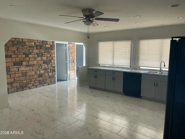 a view of kitchen with granite countertop a sink and cabinets